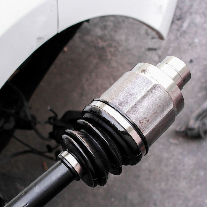 Car's exposed CV axle joint and black rubber boot near the wheel well