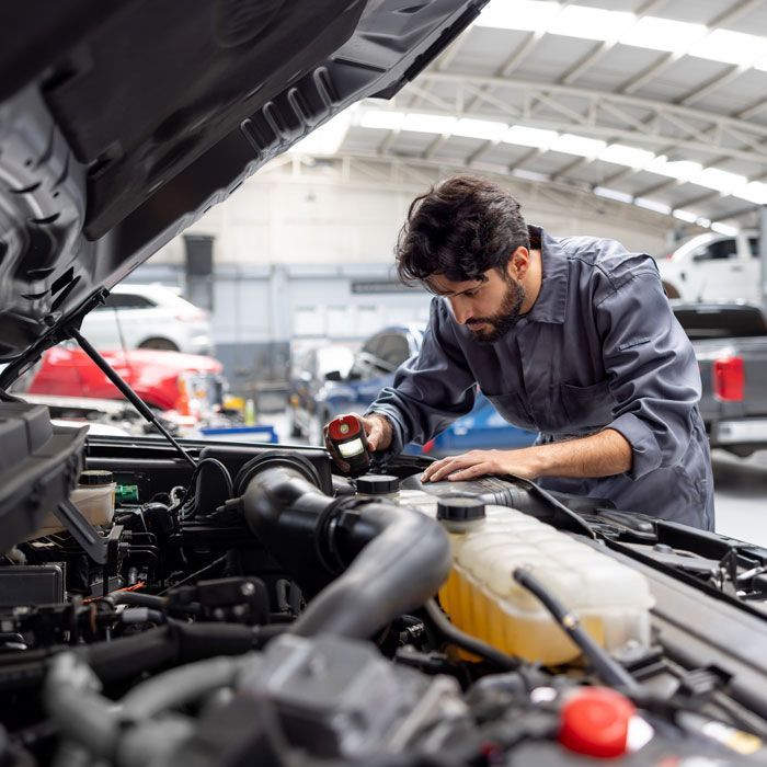 Mechanic inspecting a car engine in a bright auto repair shop