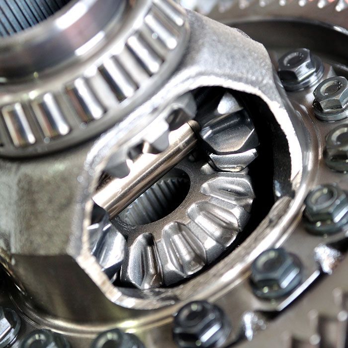 Close-up of a metal gear assembly with bolts and bearings inside a machine component