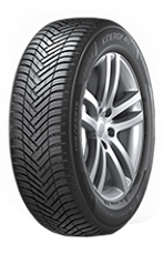 Car tire with herringbone tread on a silver alloy wheel, isolated on white background