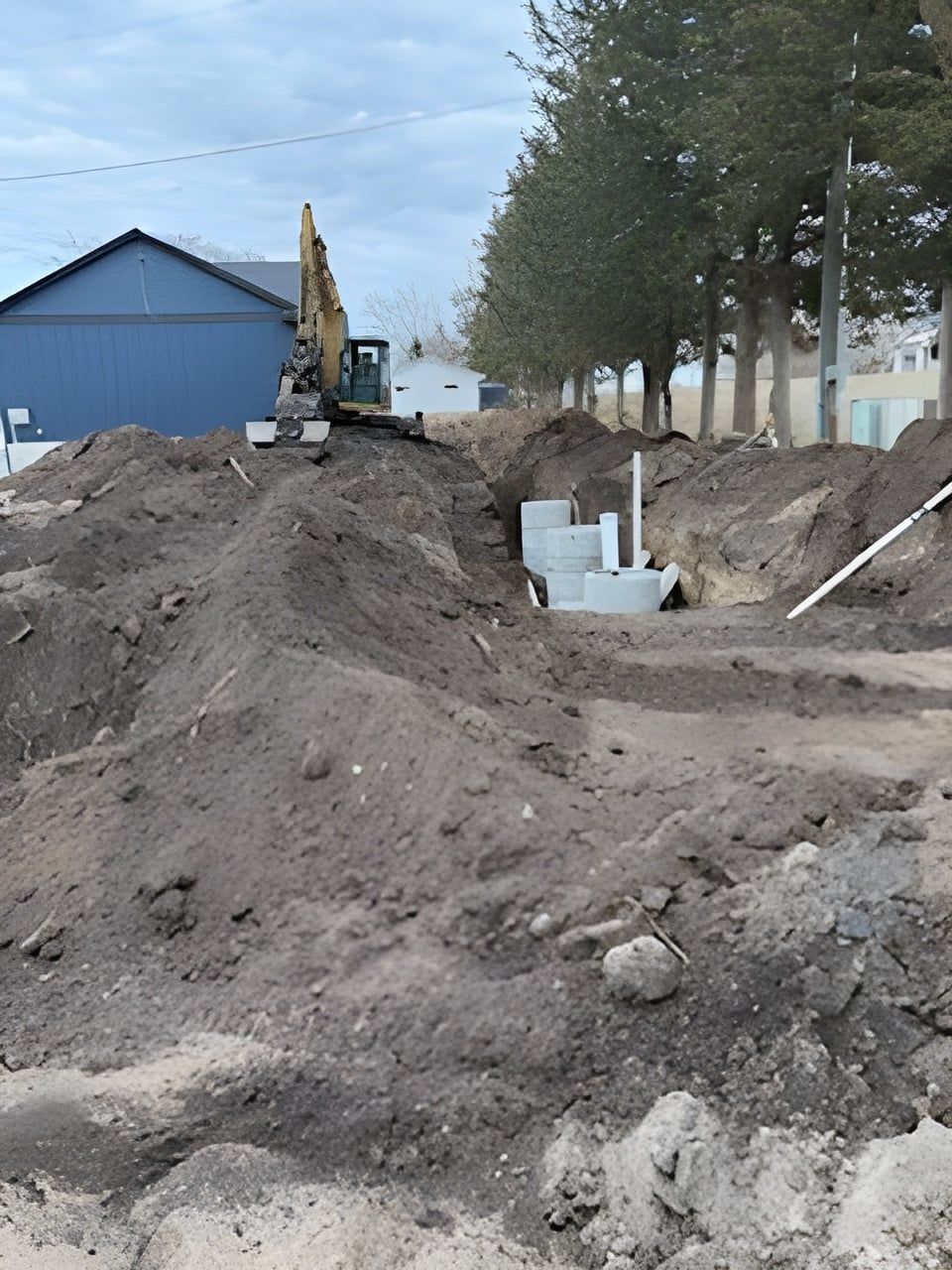 Two excavators are working on a pile of dirt.