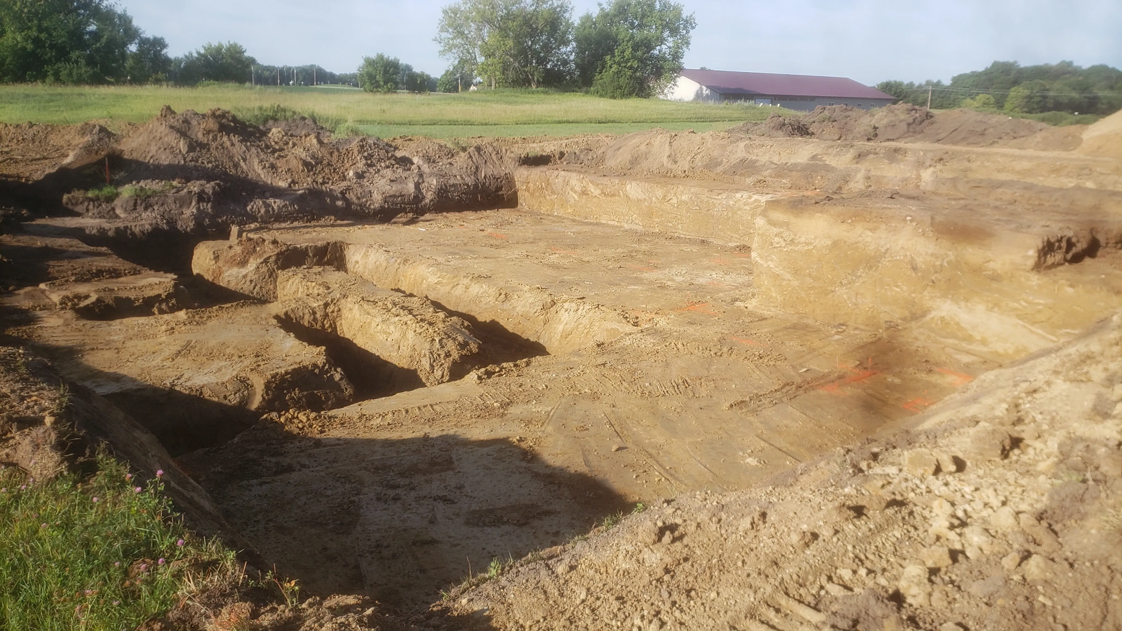 A large pile of dirt is sitting in the middle of a field.