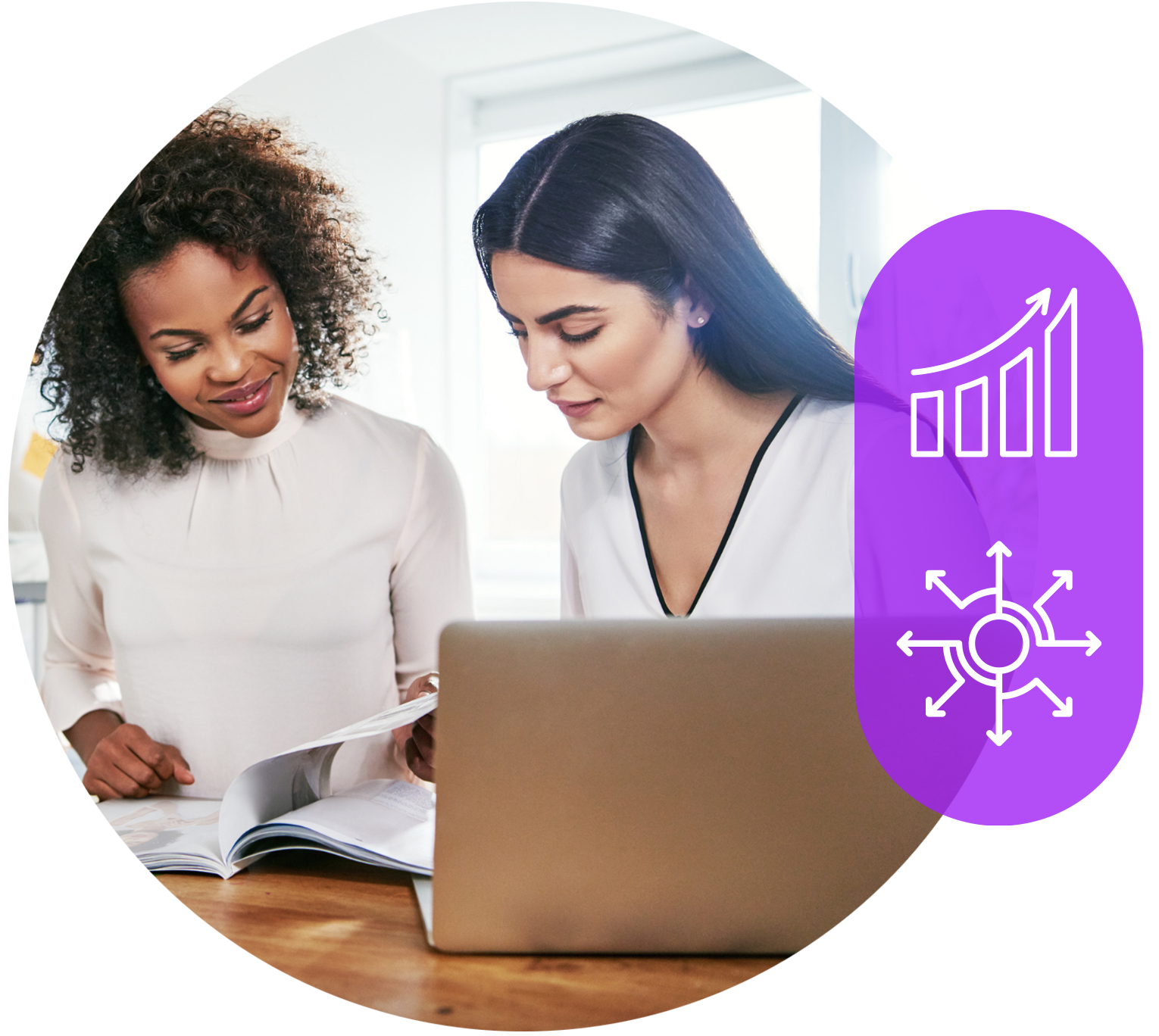 two women are sitting at a table looking at a laptop.