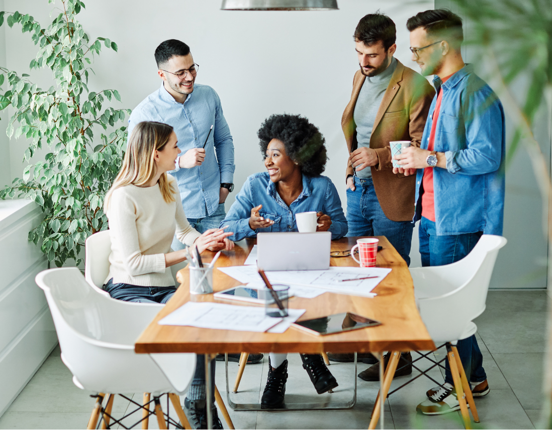 a group of people are sitting around a table having a meeting.