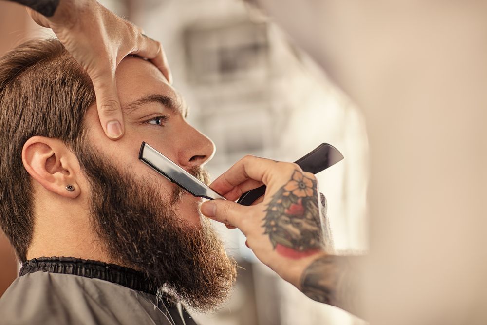Man Getting Beard Shaved With a Straight Razor in a Barber Shop — The Gentleman's Barber QLD in Toowoomba City, QLD