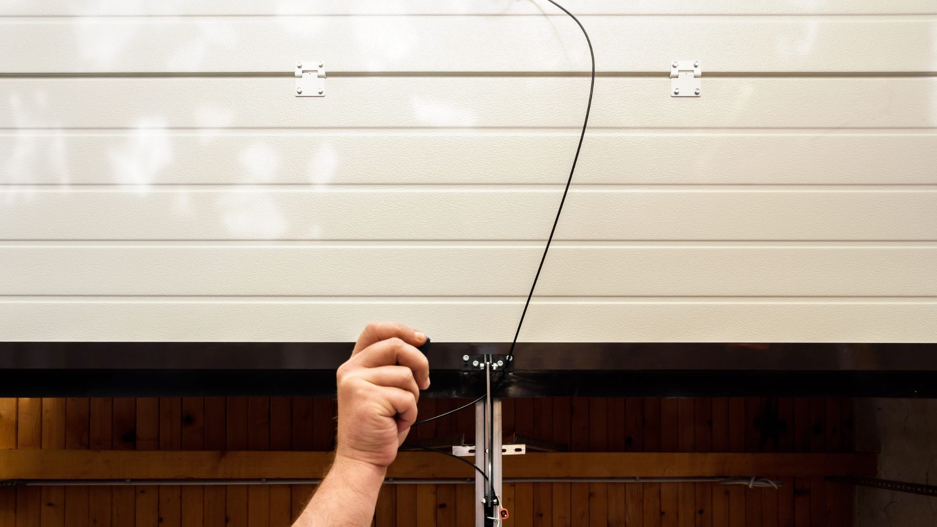 A person is opening a garage door with a chain.