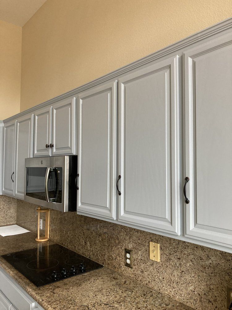 A kitchen with white cabinets and granite counter tops