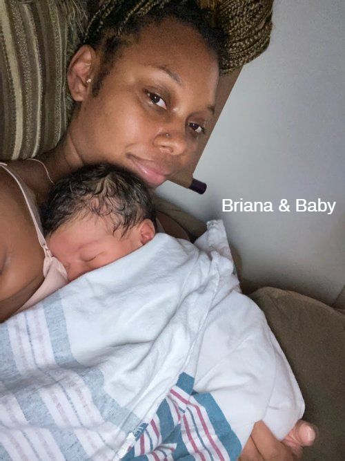 A woman is holding a newborn baby in her arms.