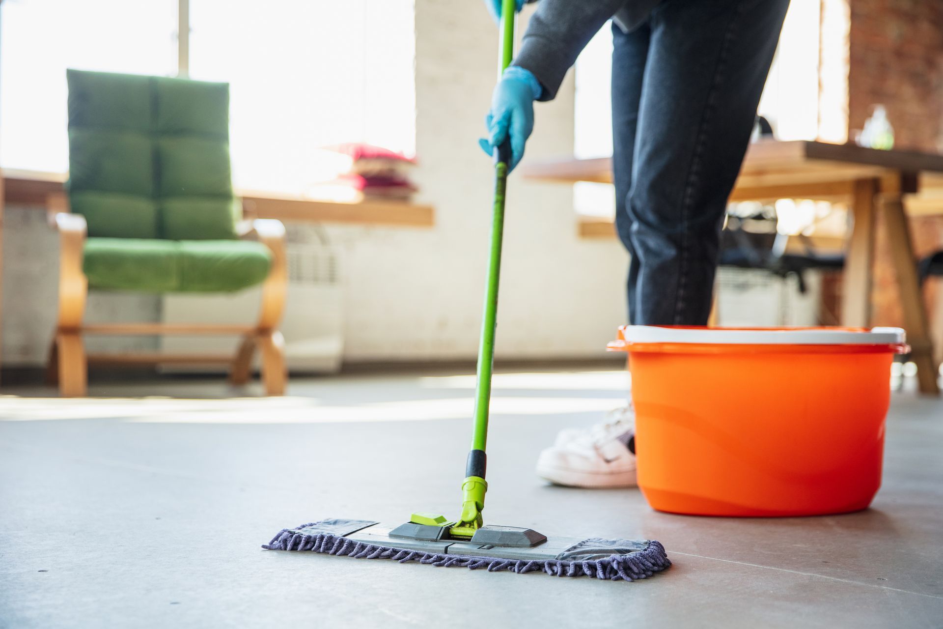 Worker mopping and disinfecting a home after a cleanout, part of Your Helpful Neighbors’ full-service cleanup in Oakland County, MI.