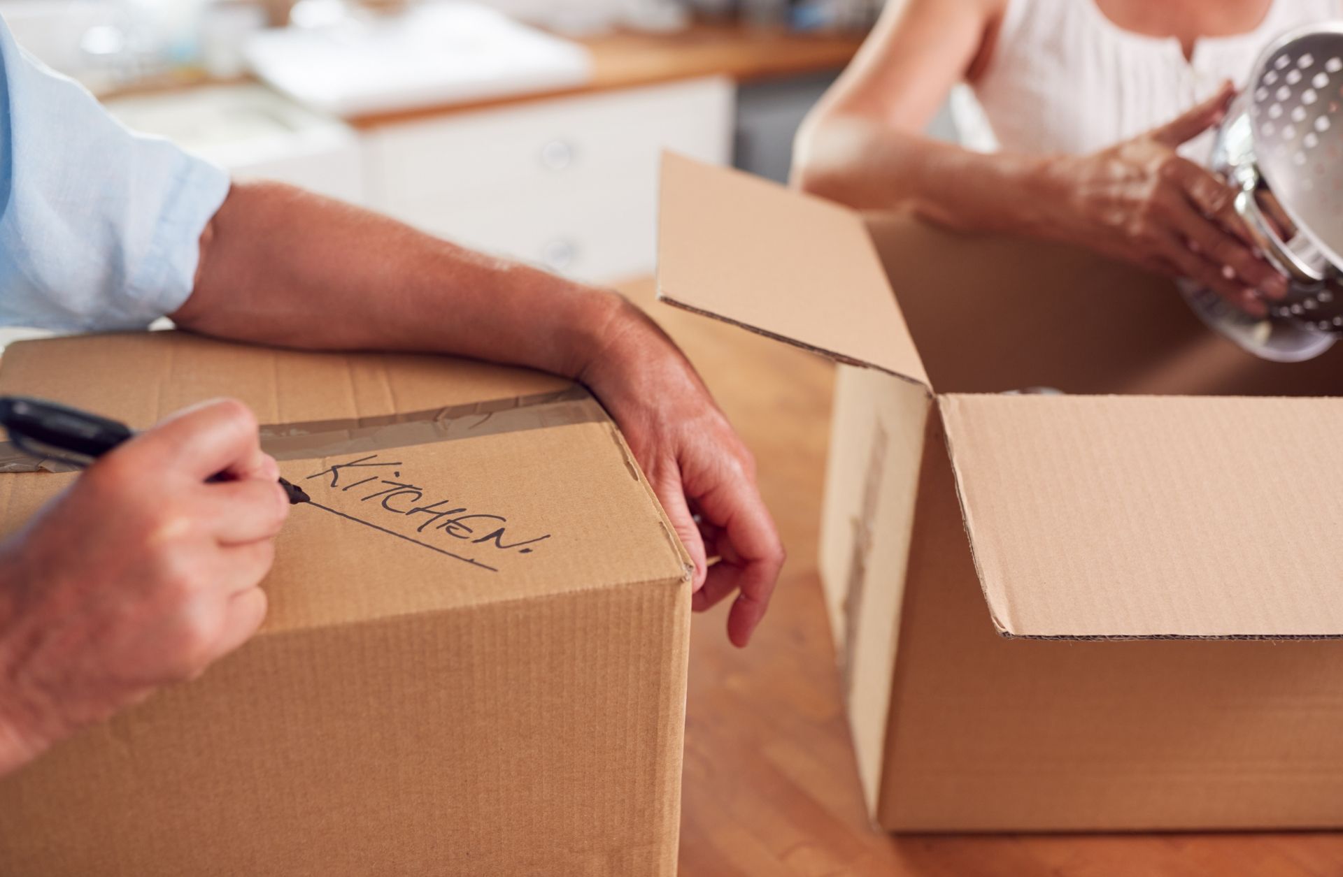 Your Helpful Neighbors helping a family pack kitchen items during a moving and downsizing service in Ferndale, Michigan.