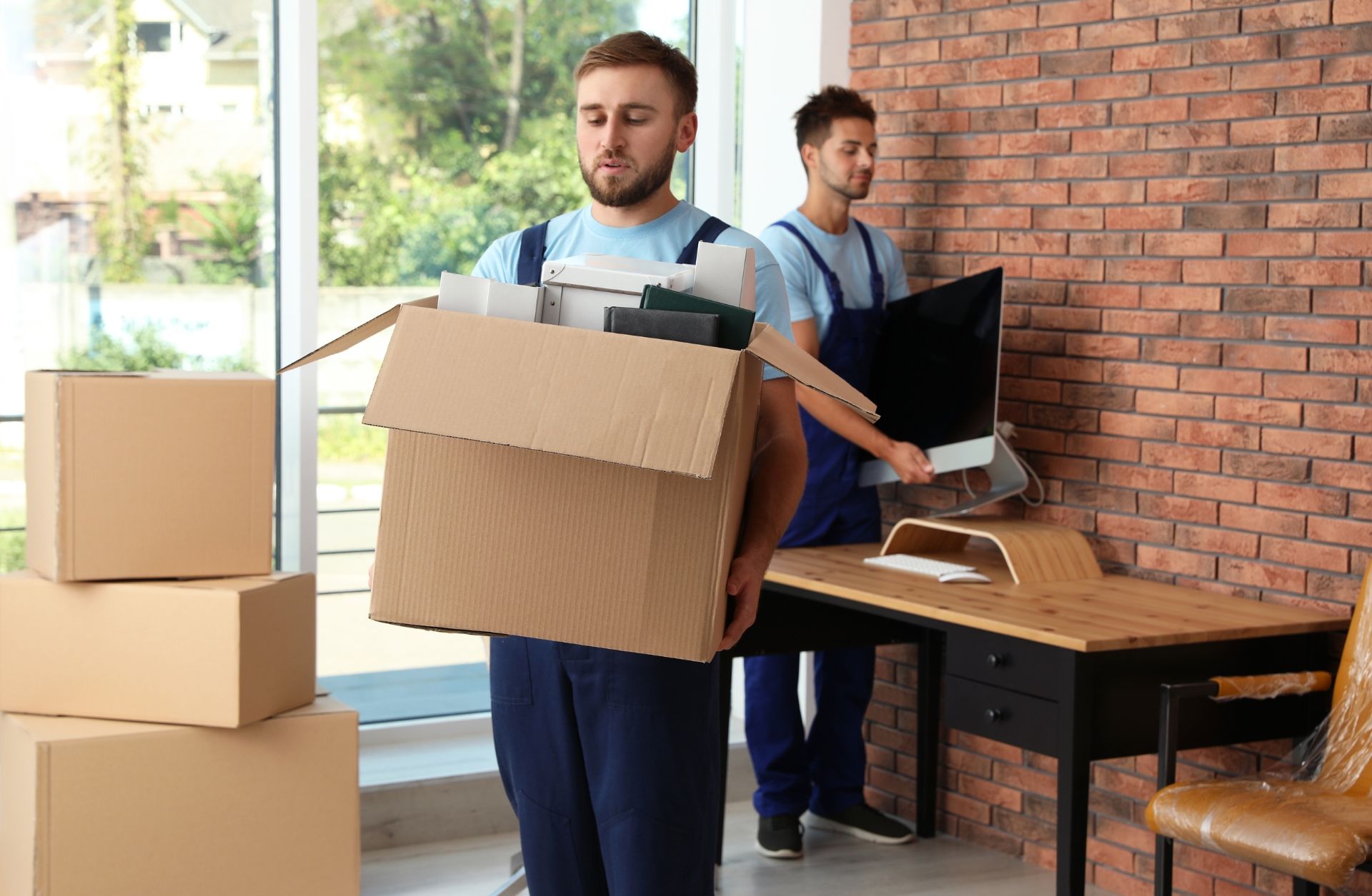 Estate cleanout professionals carrying boxes during a compassionate home cleanout by Your Helpful Neighbors in Oakland County, Michigan.”