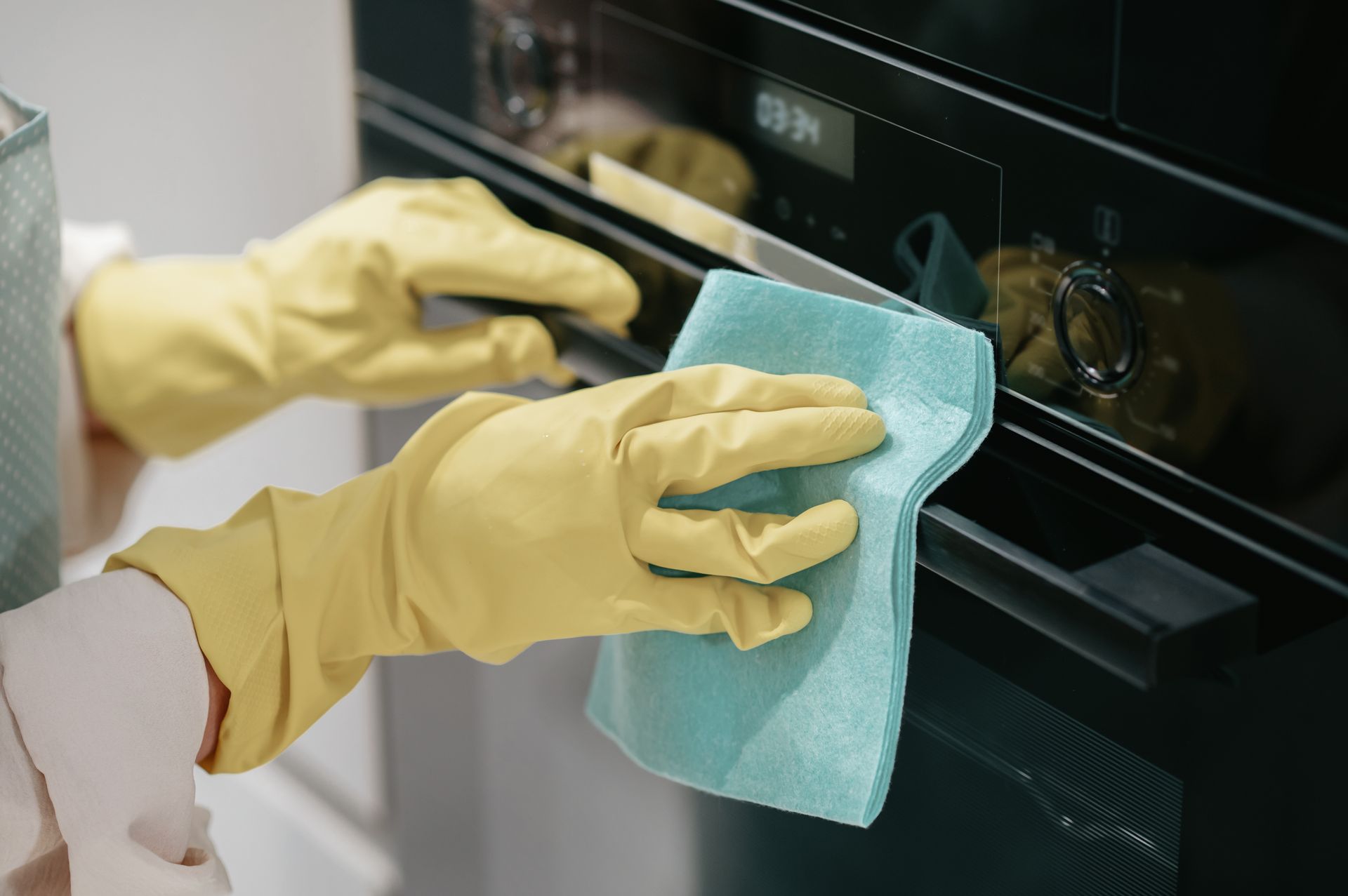 Professional cleaner wiping kitchen surfaces after junk removal and home cleanout service in Ferndale, Michigan.