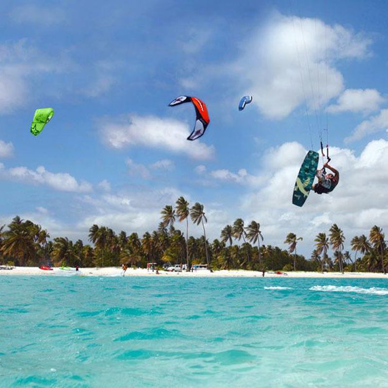 A person is flying through the air on a surfboard in the ocean