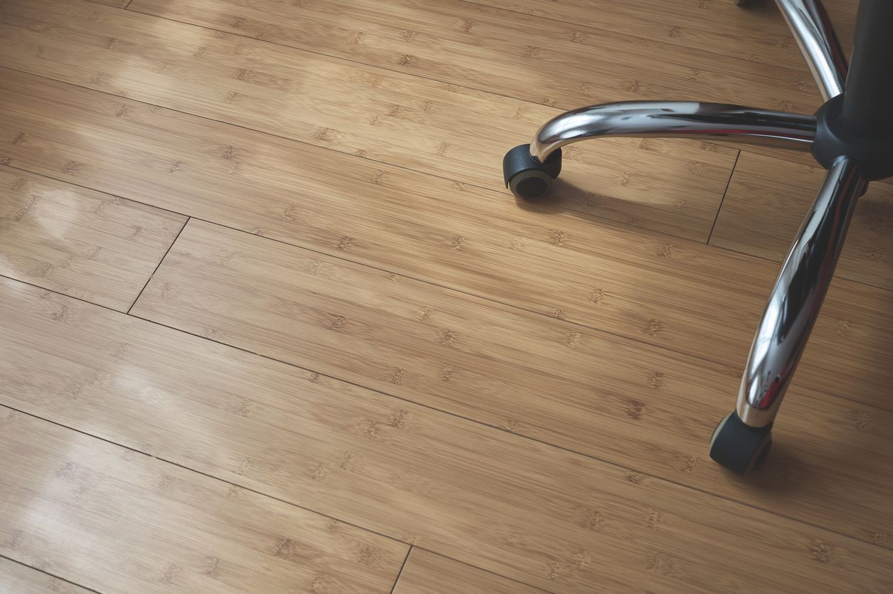 An office chair is sitting on a wooden floor.