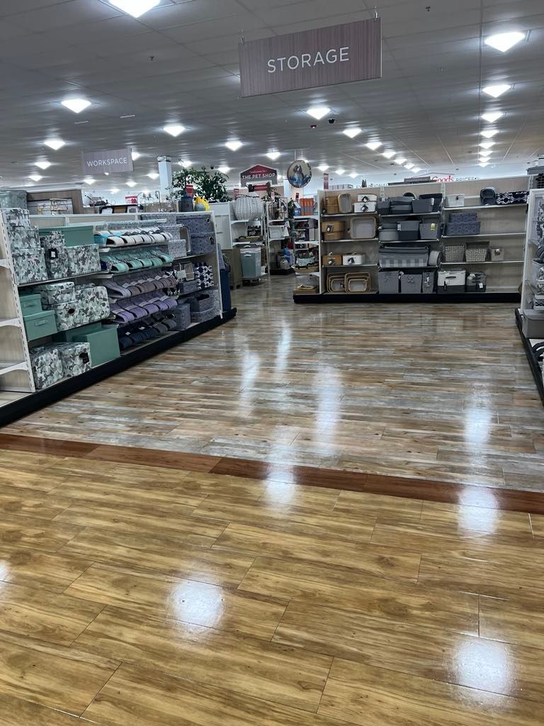 The inside of a store with wooden floors and shelves.