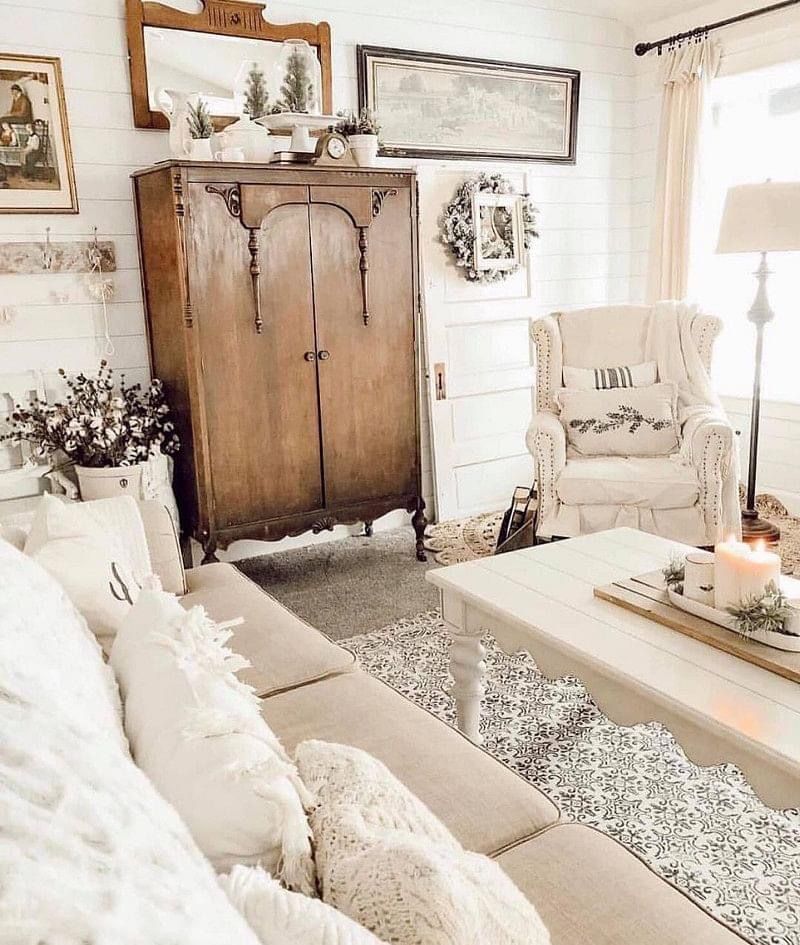 A living room with a couch , chair , coffee table and wardrobe.