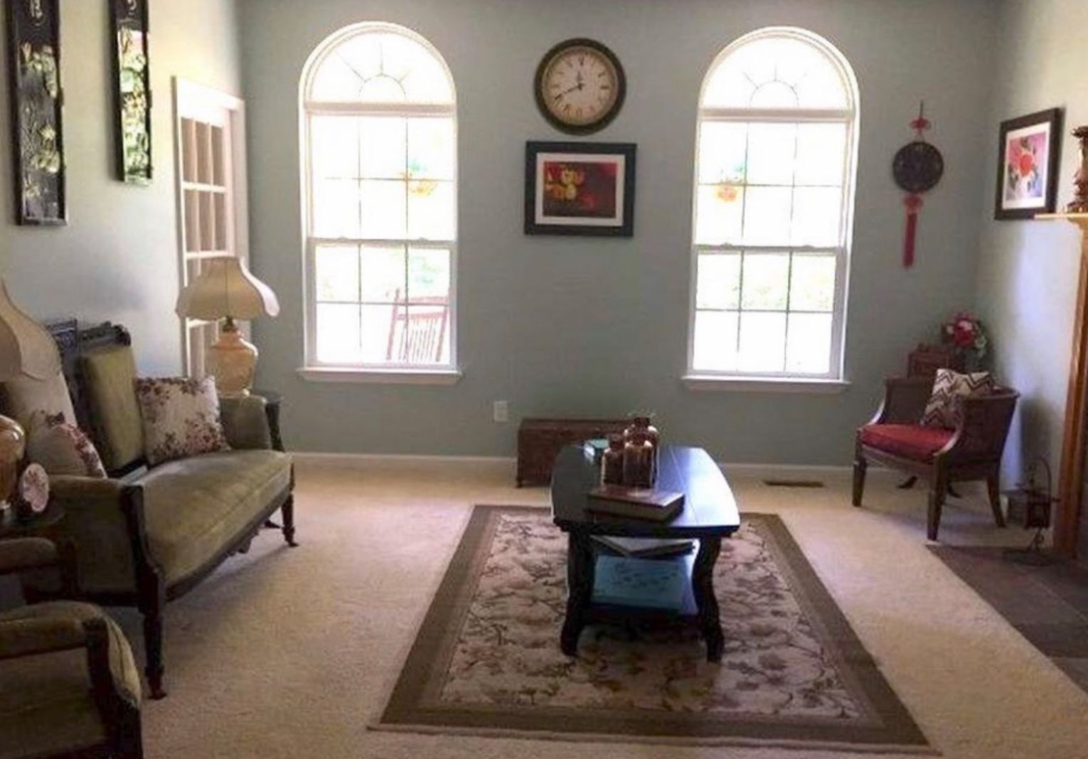 A living room with arched windows and a clock on the wall