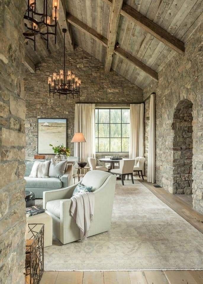 A living room with a stone wall and wooden beams