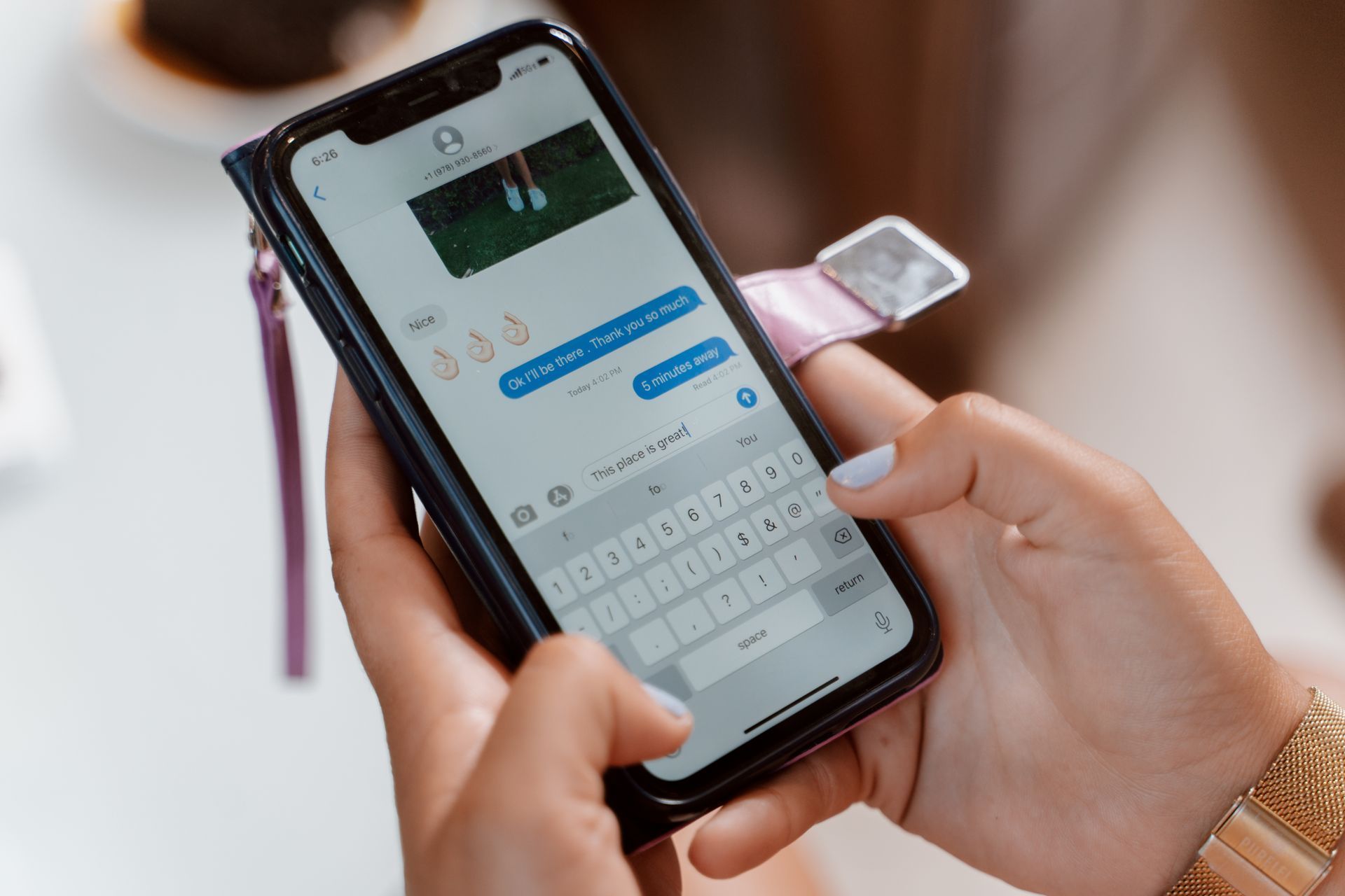 Customer typing a message on her smartphone to ask a local business a question