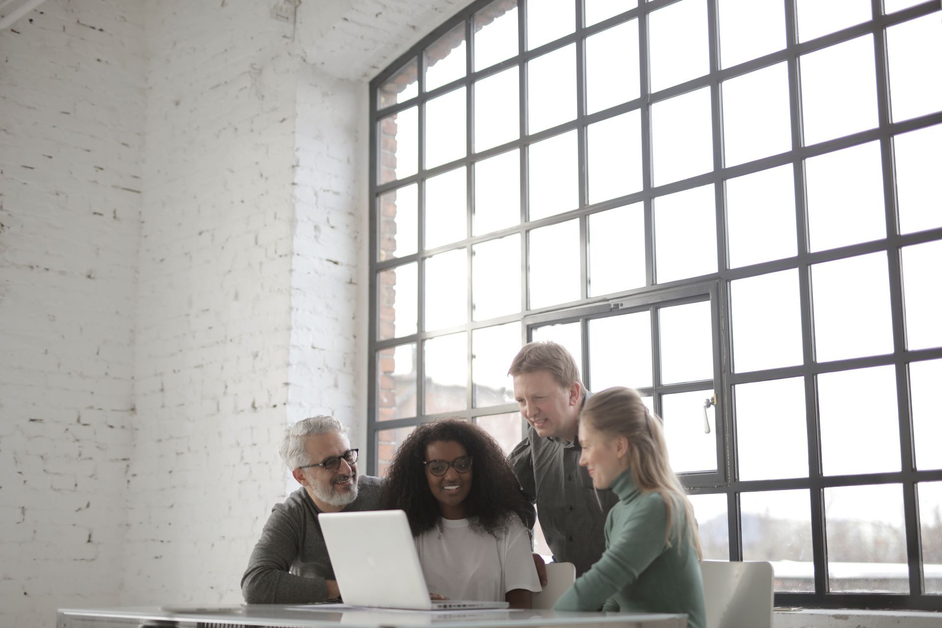 Small business team gathered around a laptop reviewing their marketing results together