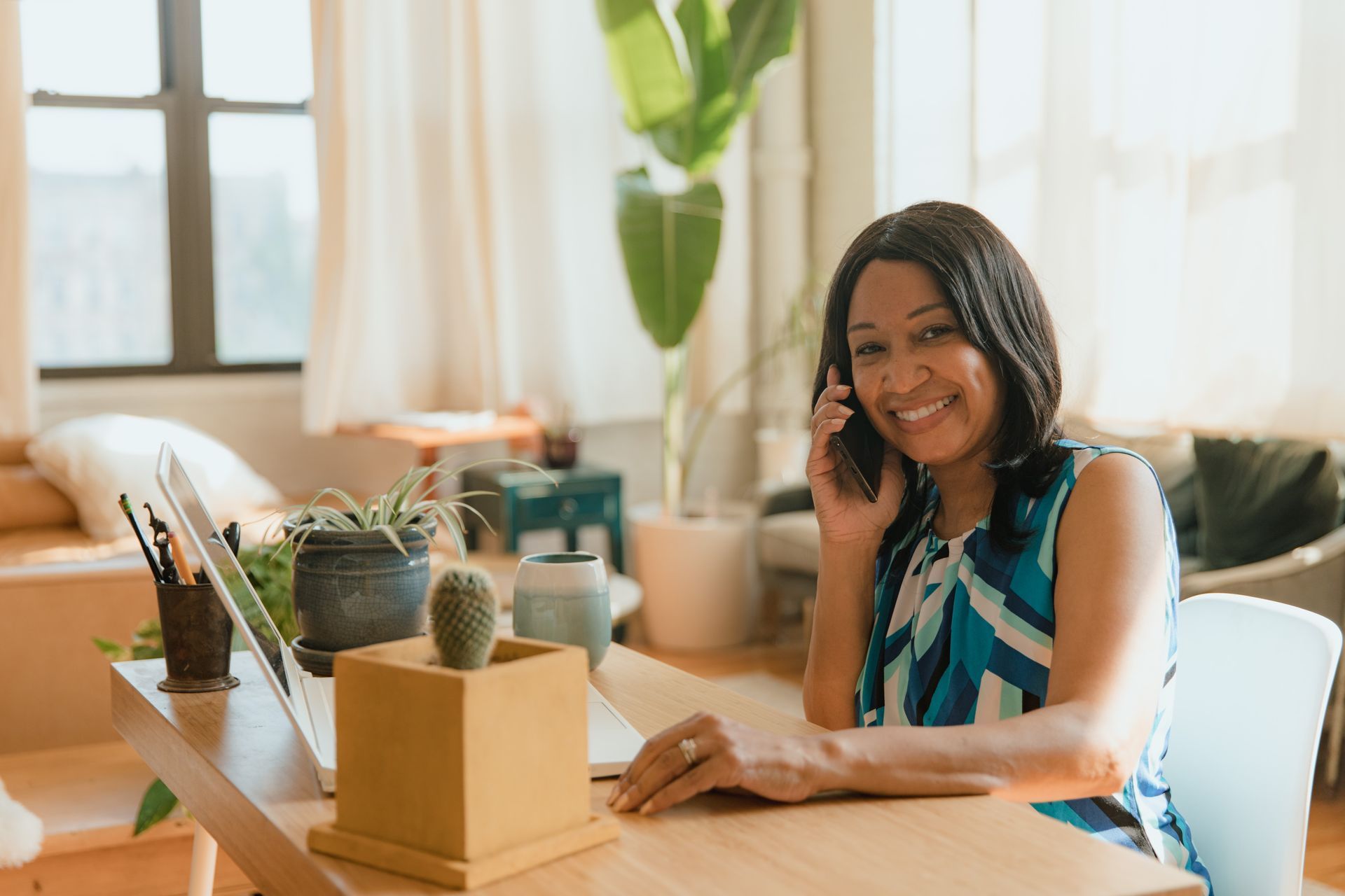 Smiling small business owner taking a customer call at her desk