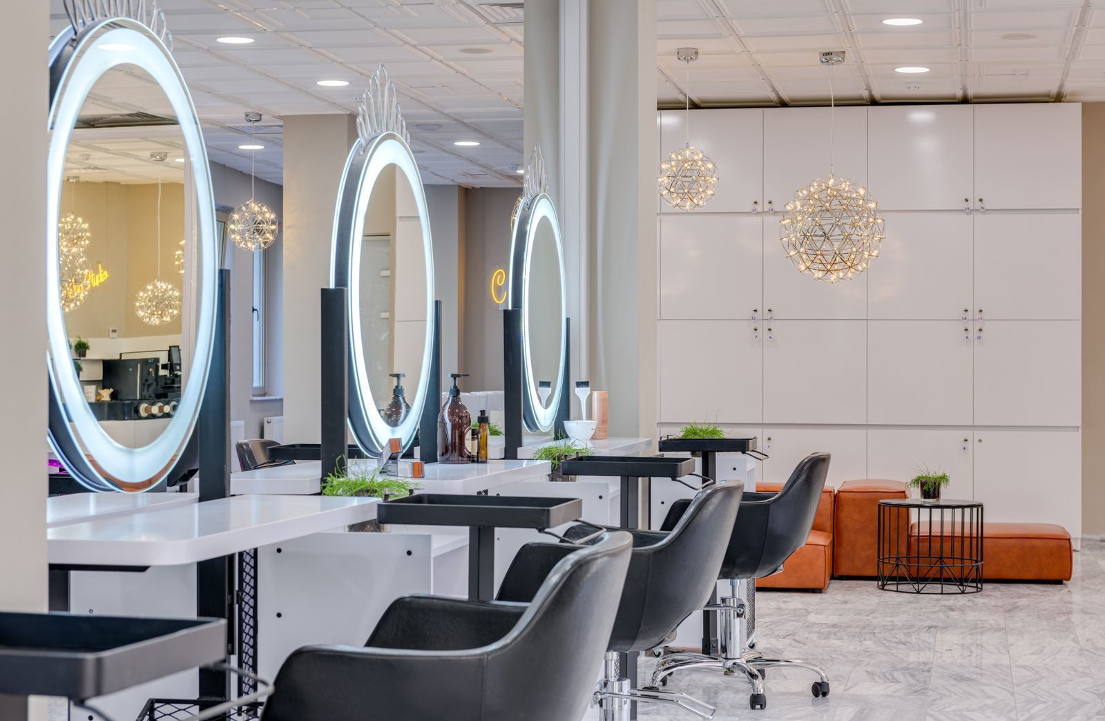 Bright, modern salon interior with styling chairs and round illuminated mirrors