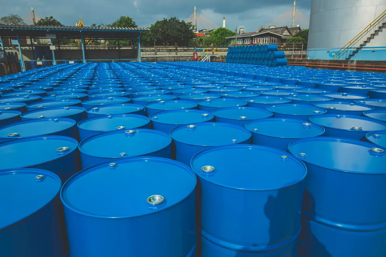 Blue barrels arranged in rows at an industrial facility, possibly for storage.