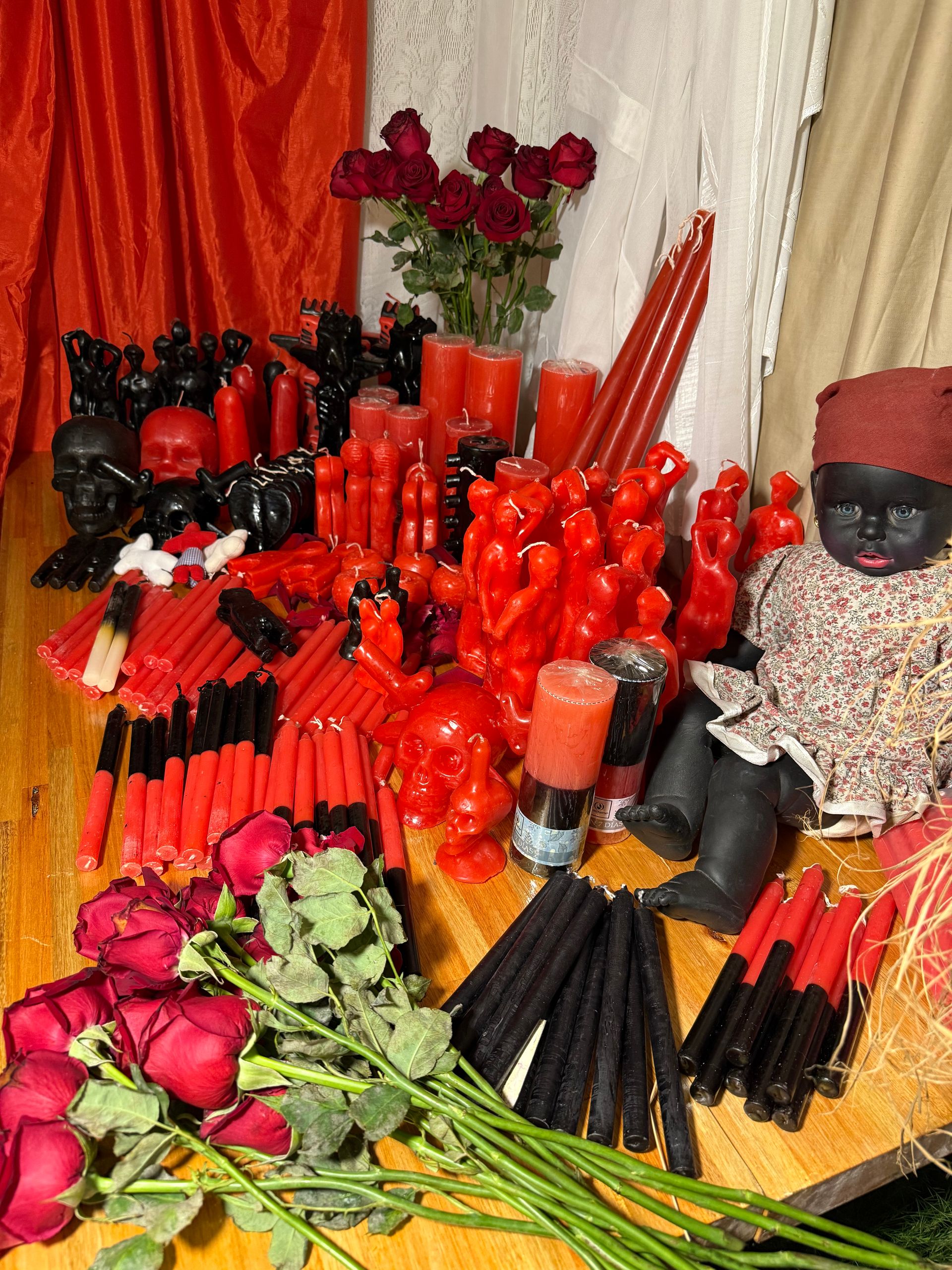 Manos colocando cartas del tarot sobre una superficie negra con cristales, velas y joyas.