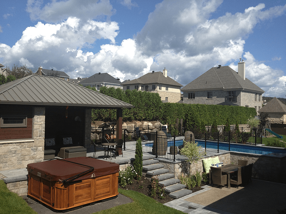 Une cour arrière avec un bain à remous et une piscine