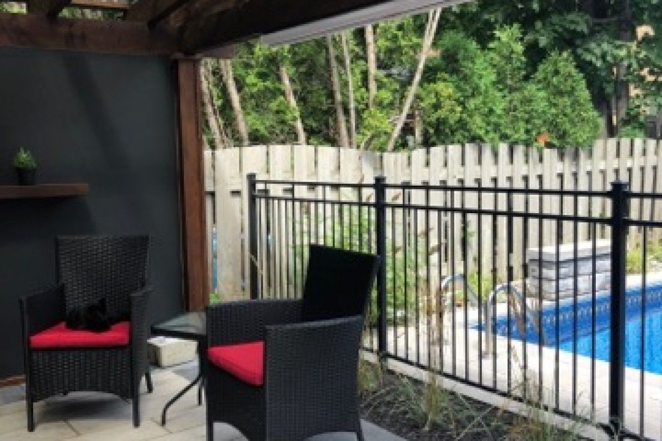 Un patio avec des chaises et une table à côté d'une piscine.