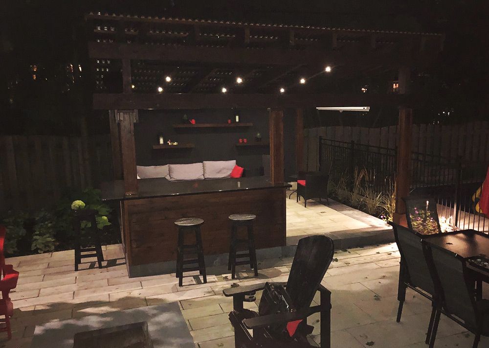Un patio avec un bar et des chaises le soir