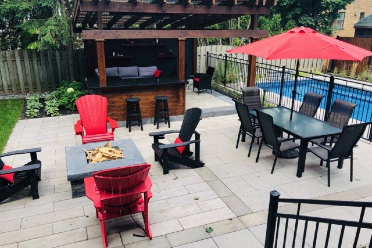 Un patio avec une table et des chaises et un parasol