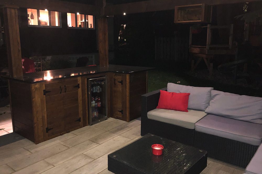 Un patio avec un canapé et une table avec une bougie dessus