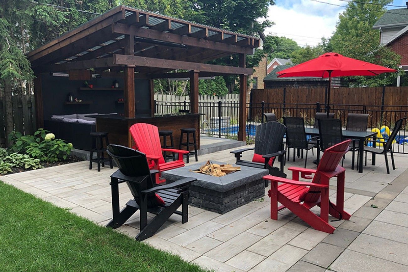 Un patio avec un foyer , des chaises , des tables et des parasols.