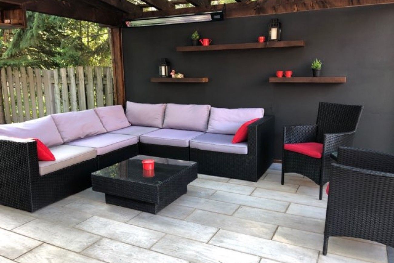 Un patio avec un canapé sectionnel, des chaises et une table basse