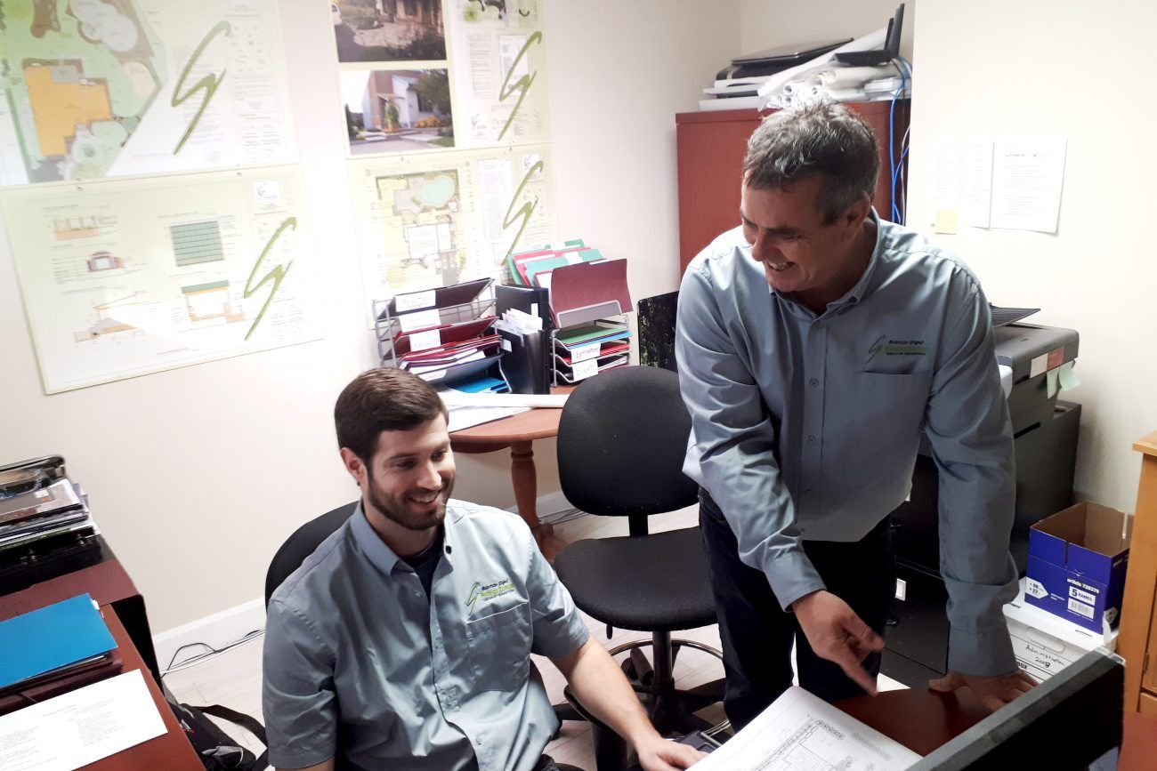 Deux hommes regardent un écran d'ordinateur dans un bureau.