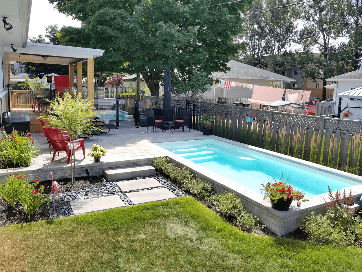 Cour arrière avec piscine rectangulaire, patio, gazebo, pelouse et aménagement paysager.