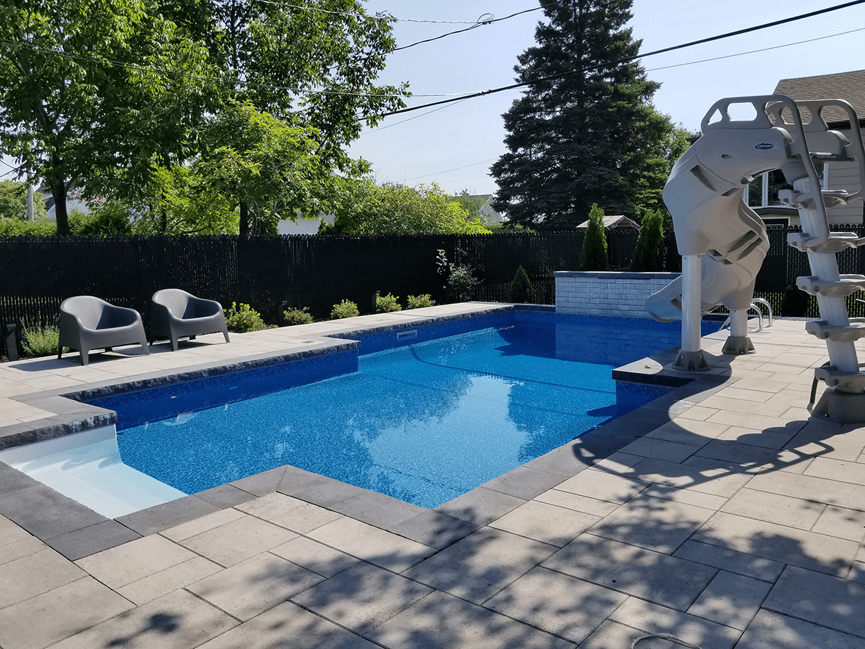 Une grande piscine avec toboggan dans la cour