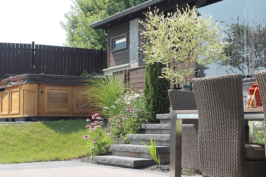 Une table et des chaises devant une maison avec un bain à remous en arrière-plan