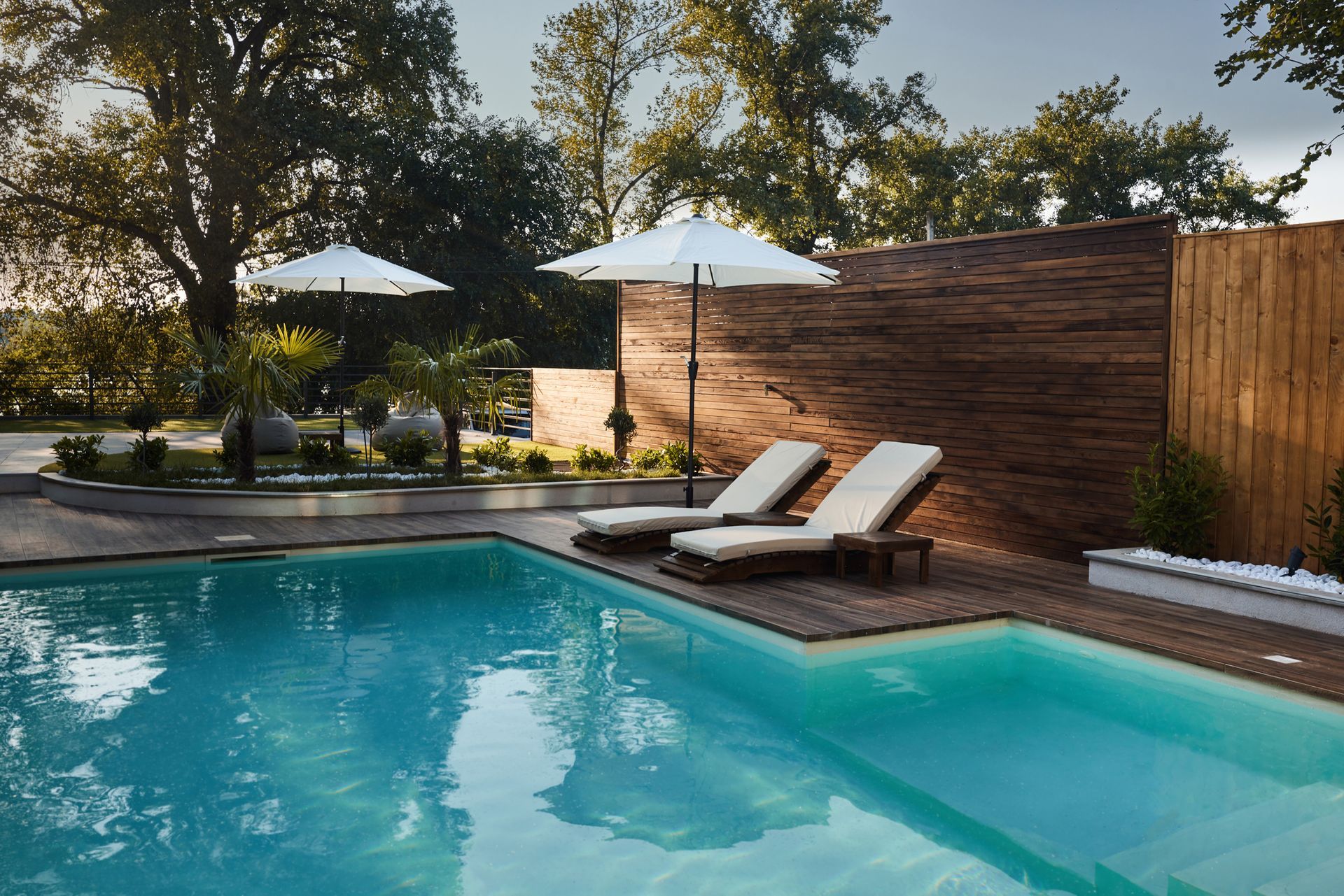 A swimming pool with chairs and umbrellas around it