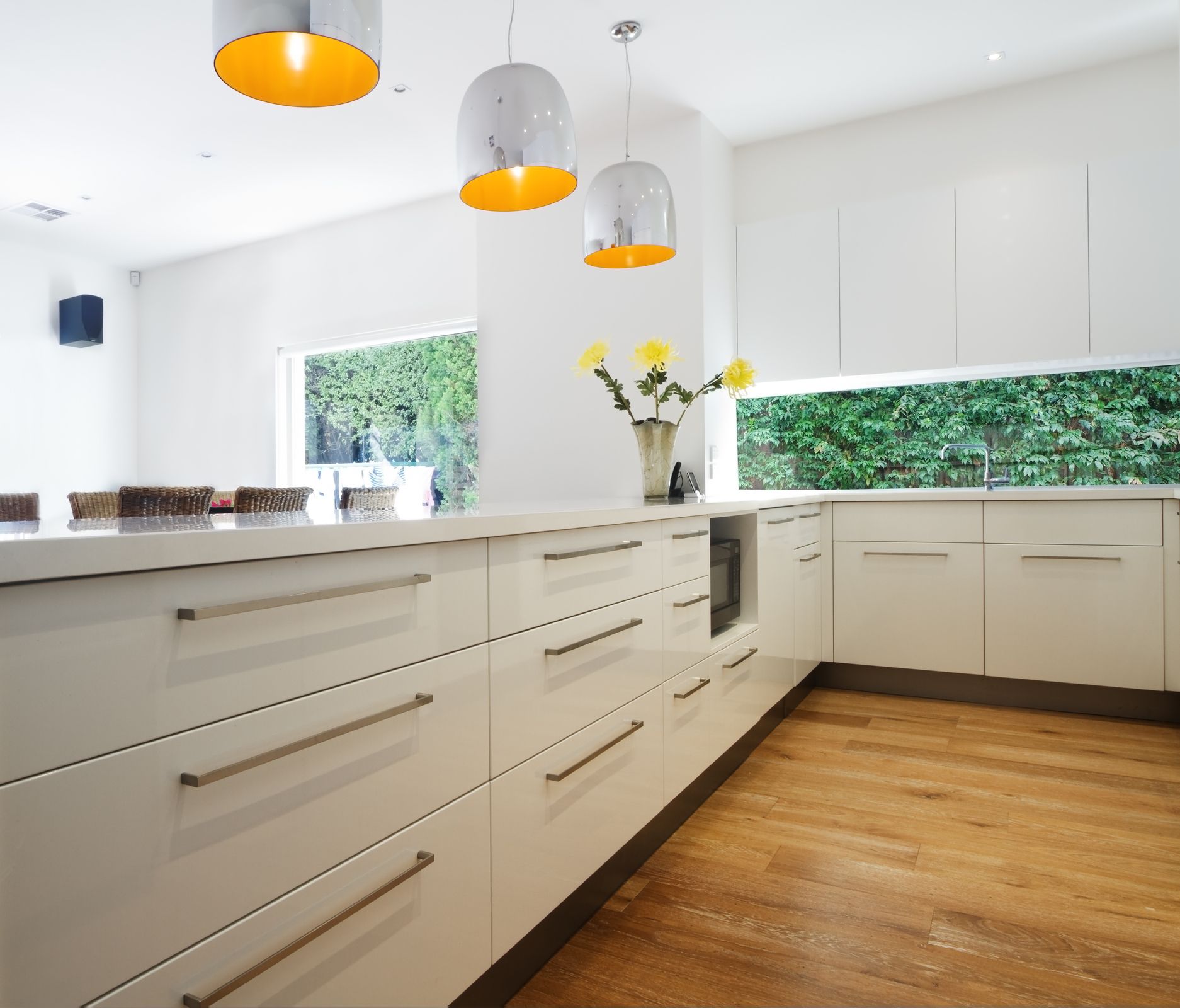 A kitchen with white cabinets and wooden floors