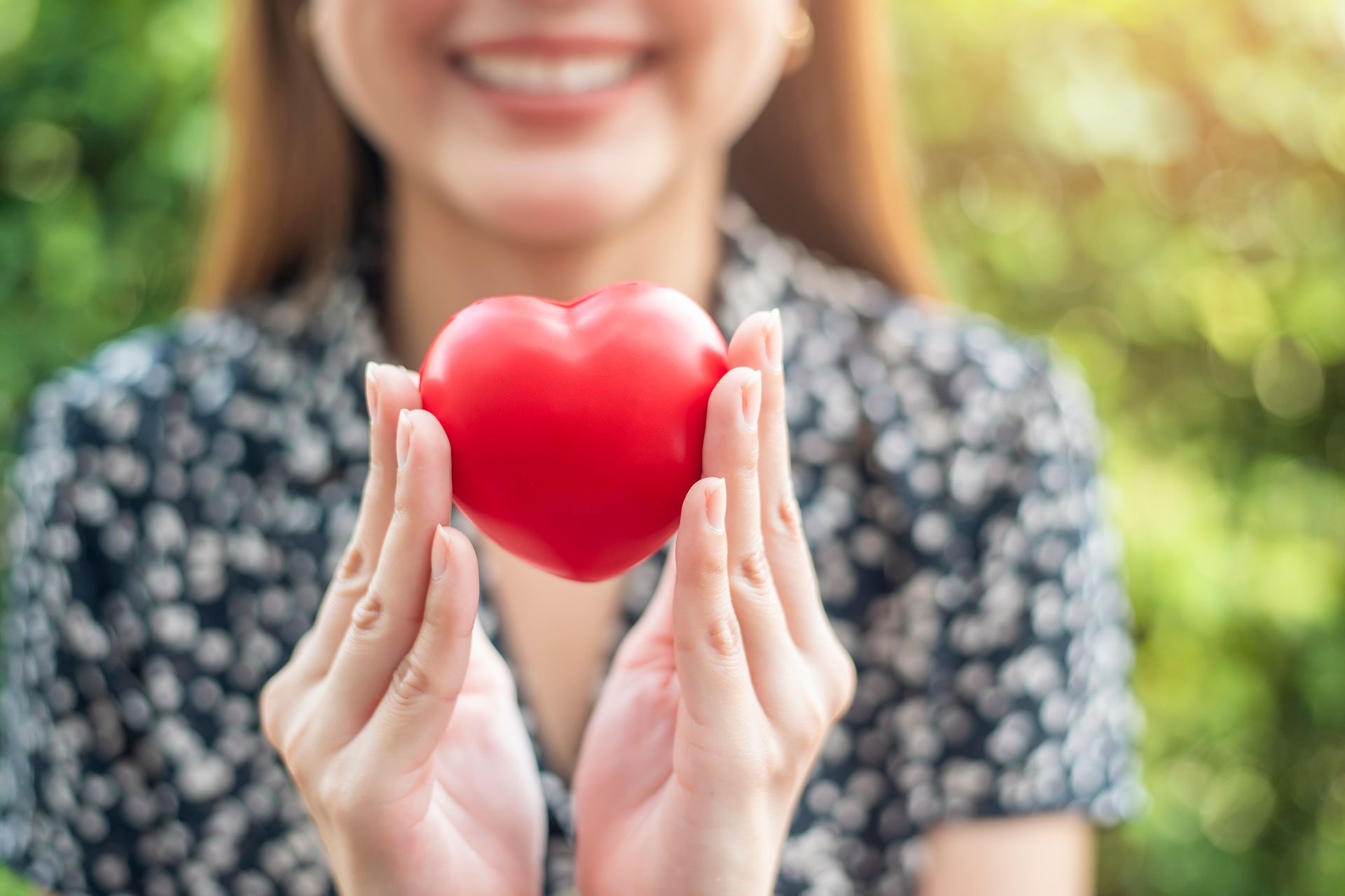Photo of woman happily holding toy heart