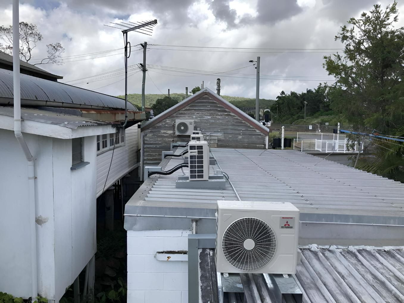 A White Air Conditioner Is Sitting On The Roof Of A Building — Beards Refrigeration & Air Conditioning in Rural View, QLD