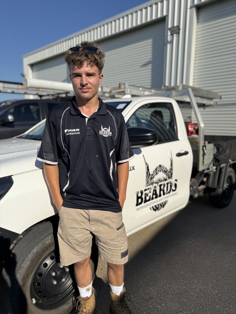 A Man With A Beard Is Standing Next To A White Truck — Beards Refrigeration & Air Conditioning in Bucasia, QLD
