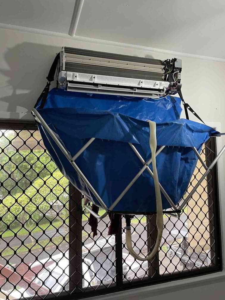 An Air Conditioner Is Hanging From The Ceiling With A Blue Bag Attached To It — Beards Refrigeration & Air Conditioning in Bucasia, QLD