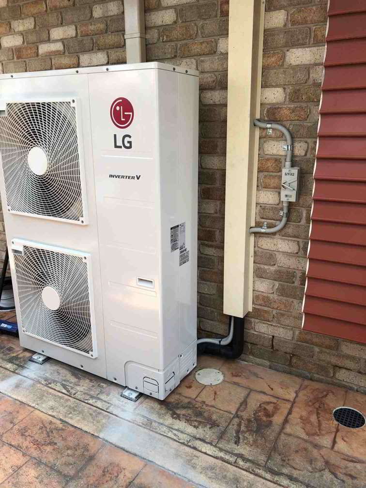 An Lg Air Conditioner Is Sitting On The Side Of A Brick Building — Beards Refrigeration & Air Conditioning in Rural View, QLD