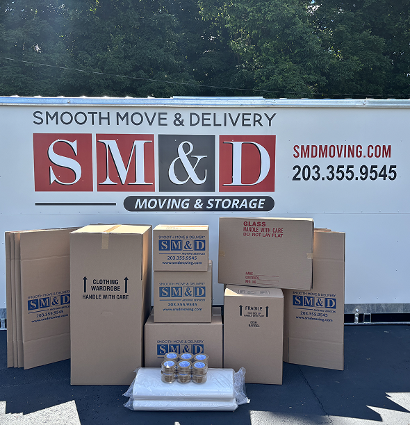 Moving boxes and supplies in front of a Smooth Move & Delivery truck, outdoors.