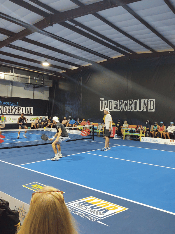 A group of people are playing tennis on a court that says underground
