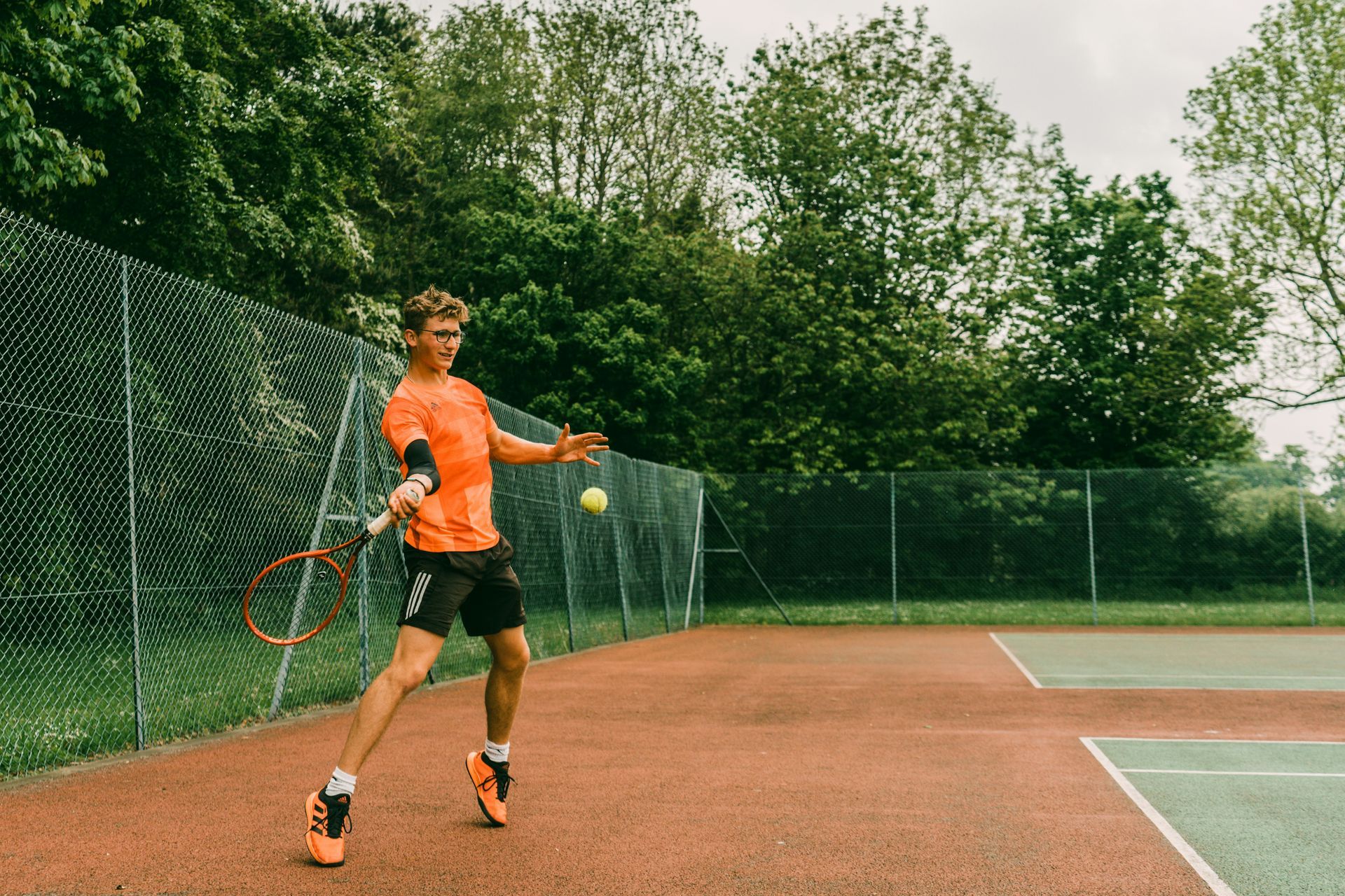 a man is holding a tennis racquet on a tennis court