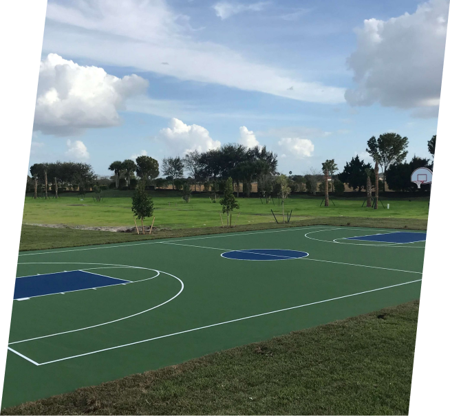 a basketball court in a park with trees in the background